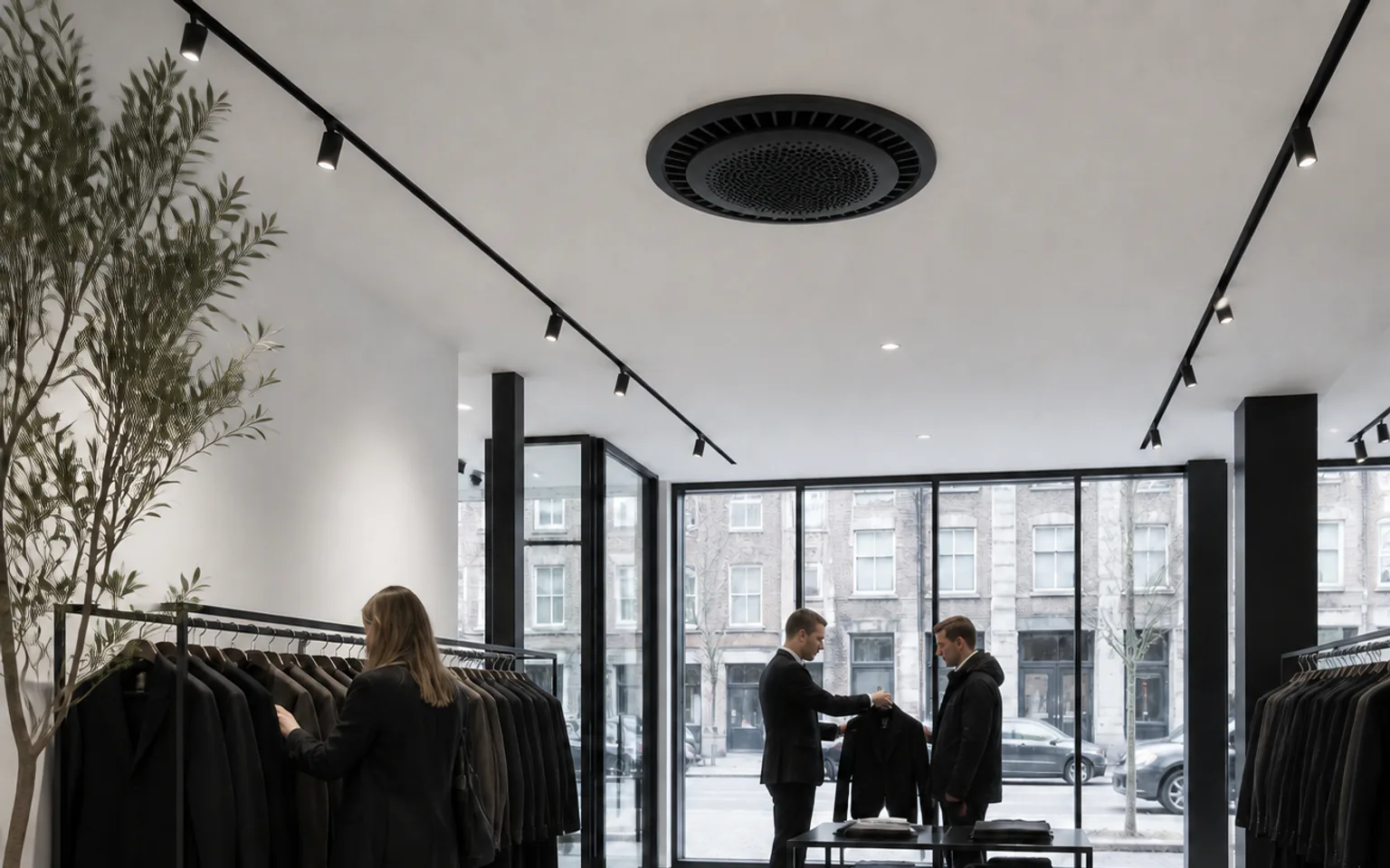 Klanten krijgen advies in een modewinkel met een zwarte ronde plafondcassette