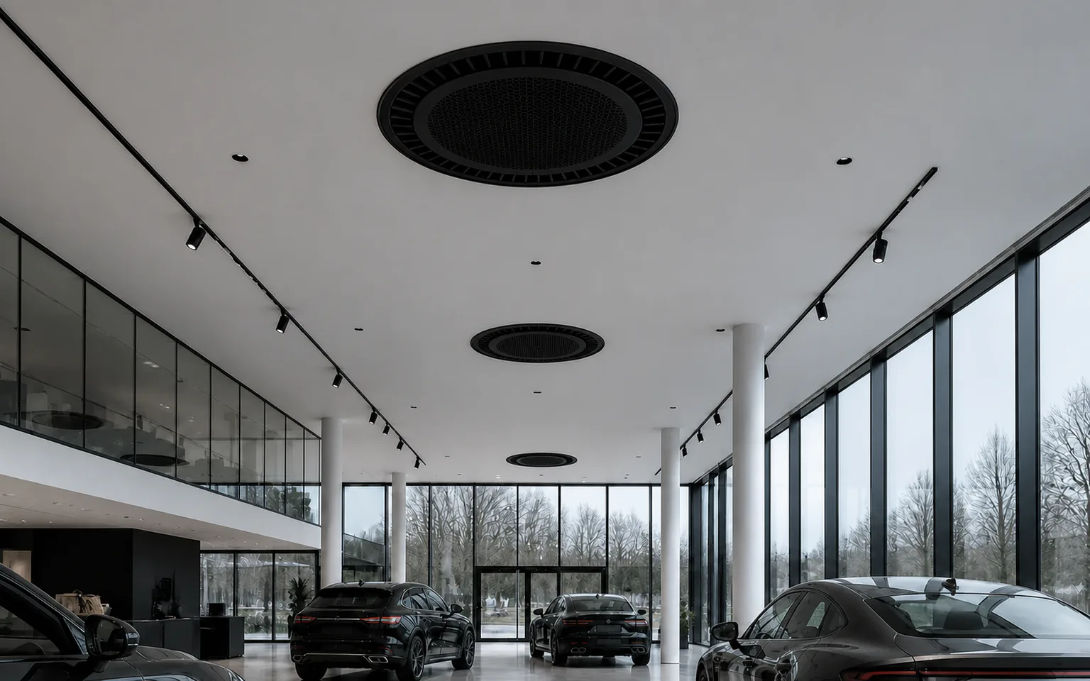 Autoshowroom met grote glasgevels, hoge ruimte en zwarte ronde plafondcassettes